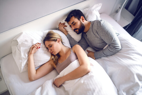 Young couple lying in bed and sleeping.
