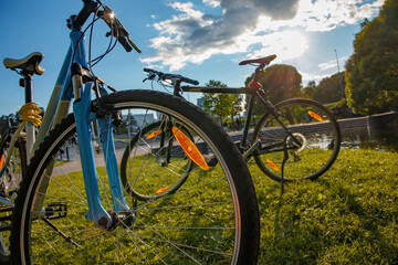 Fototapeta na wymiar Two bicycles parked in a city park in the contrasting light