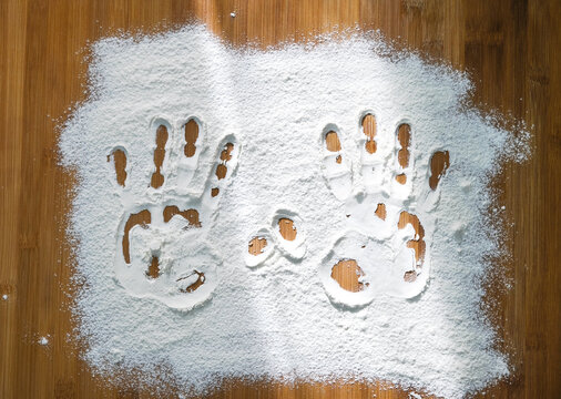 kitchen board with flattened flour and handprints