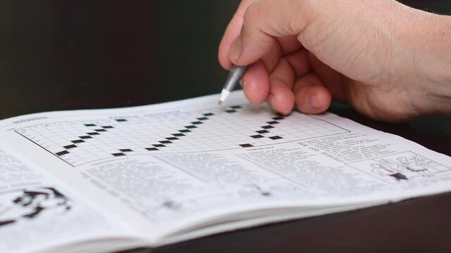 un uomo si rilassa compilando un cruciverba