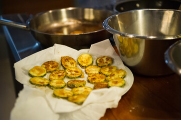 Fried zucchini rings on a tissue soaking oil. Almost ready to serve vegetarian food.