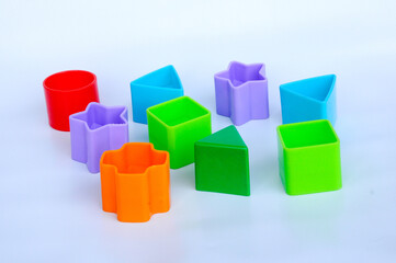 Isolated children's toy blocks in various shapes made of plastic on white background 