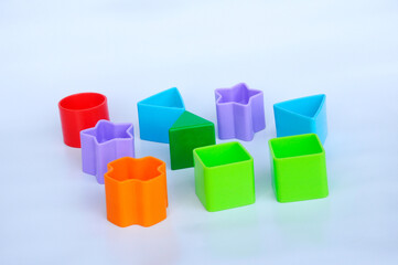 Fototapeta na wymiar Isolated children's toy blocks in various shapes made of plastic on white background 