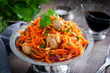 Spicy salad with champignons and Korean carrots in a metal vase, selective focus