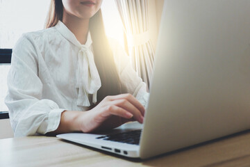 Close up shot of a  woman working with a laptop at home in formal attire.