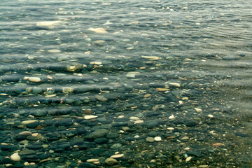 transparent sea water above beach stones