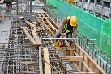 
MALACCA, MALAYSIA -JULY 12, 2016: Construction workers fabricating timber formwork at the...