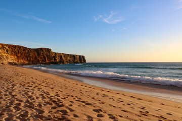 Footprints left in the sand on a beach in Algarve, Portugal.	

