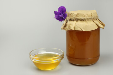 Honey in a jar covered with paper and wild flowers