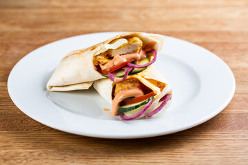 roll with chicken nuggets and fresh vegetables, red onions and cream sauce