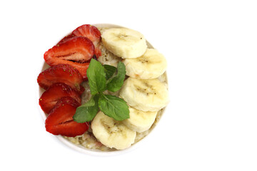 Oatmeal with strawberries, banana and mint isolated on white