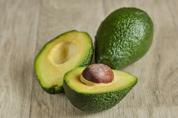 Two fresh ripe raw hass avocados, close up, healthy food concept. On a table of gray boards.