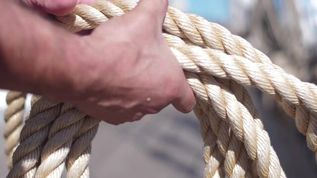 crew member tidying rope in wood ship vessel slow motion