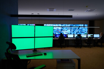 Empty interior of big modern security system control room with blank green screens