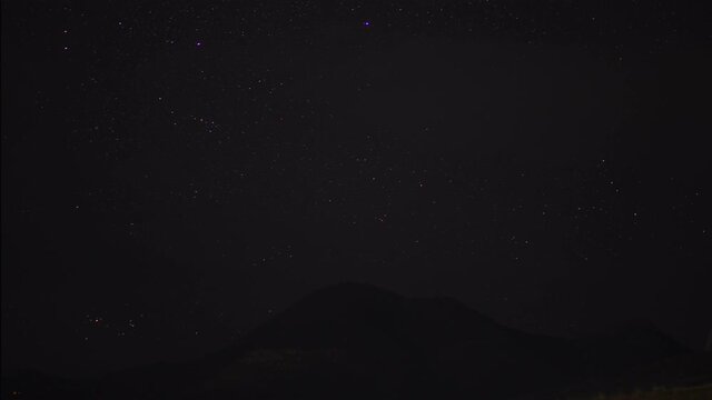 timelapse movement of stars in the night sky over the mountain range