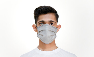 Boy wearing face mask looking in camera, young boy wearing mask due to corona virus covid 19