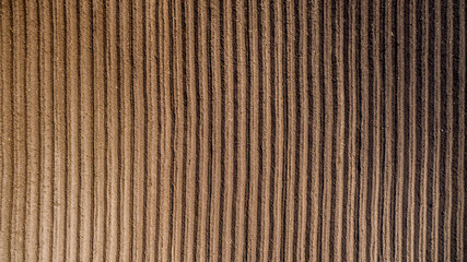 Aerial view ; Rows of soil before planting. Furrows row pattern in a plowed field prepared for...