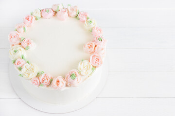 Beautiful cake with pink and white creame roses.Wooden board, white background, empty space