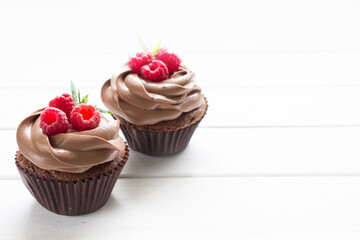 Chocolate cupcakes with fresh raspberries , white background