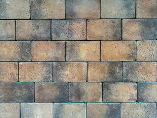 Brick wall texture background material with with wide bricks. Wall of gray-brown large relief brick. Pattern for designers.
