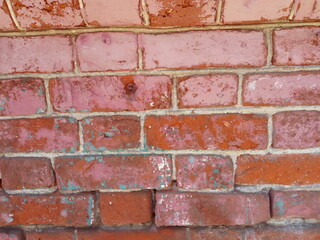 Obraz premium Brick wall. Red brick painted with front beige paint. Paint is missing in some places. Looks through the structure of the brick and cement mortar.