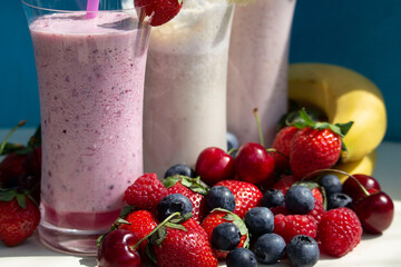 fresh fruit smoothie milkshake with berries blue background