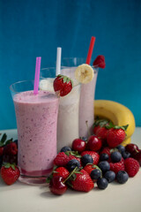 fresh fruit smoothie milkshake with berries blue background