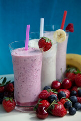 fresh fruit smoothie milkshake with berries blue background