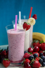 fresh fruit smoothie milkshake with berries blue background