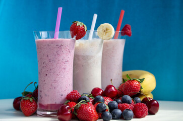 fresh fruit smoothie milkshake with berries blue background
