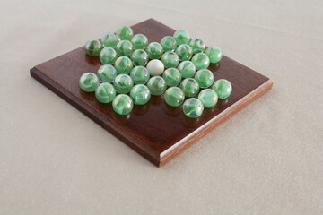 glass marble solitaire game on wooded board 