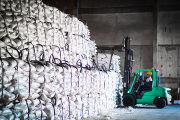 Forklift stacking up sugar bag inside warehouse, sugar warehouse operation. Agriculture product storing and logistics for import and export.