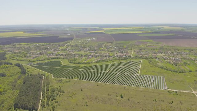 Solar panel produces green, environmentaly friendly energy from the setting sun. Aerial view from drone. Landscape picture of a solar plant that is located inside a valley