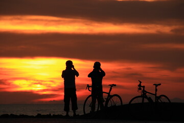 Obraz na płótnie Canvas silhouette of a couple on bicycles at sunrise