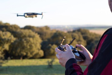 hands of a man holding a joystick to fly a drone