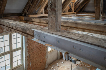 Fototapeta na wymiar in old building old wooden beams are reinforced with steel beams