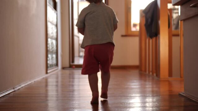 Toddler baby child girl walks barefoot on parquet floor at home
