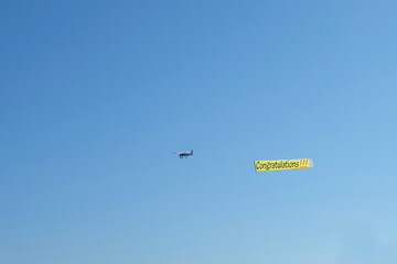 The plane in the sky has a message with congratulatory letters.