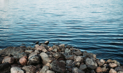 View at calm blue sea and stone shore. Nature nordic landscape.