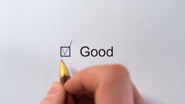 Good - Customer Service Evaluation Form. Assessment checkbox marking with the inscription GOOD. Raiting Survey. Good - male hand pointing a tick in the checkbox on white paper with pen
