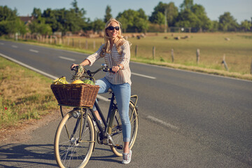 Middle-aged blond woman shopping for groceries on her bicycle