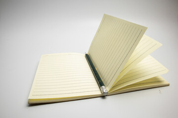 Book and pencil top view copy space on white background