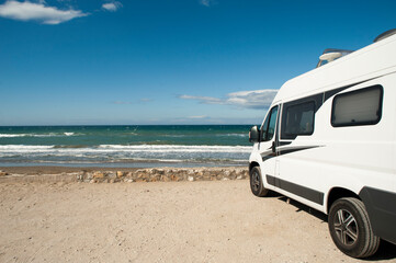 Fototapeta na wymiar Camping on the beach. Holidays Camper Van.mar and blue sky in the background