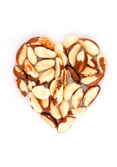 Heart shaped organic brazil nuts containing natural minerals and vitamin, concept of healthy nutrition on a white background
