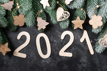 Happy New year 2021. Wooden Christmas or new year decorations on Christmas tree branches. Christmas background with wooden numbers 2021