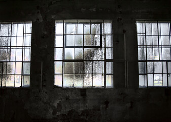 Big dirty windows in an old empty industrial interior, abandoned factory, moody bright light