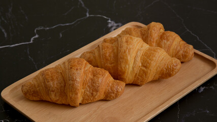 Fresh croissants on dark stone background.