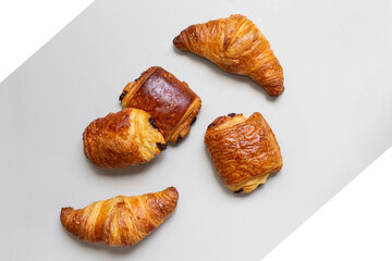 Fresh homemade croissant on white marble background.