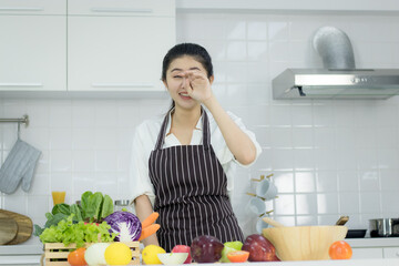 Asian young woman with glass of orange juice sitting at kitchen table,Health food concept