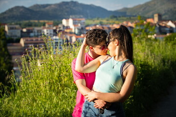 Fototapeta premium Boy kissing girl in the field at sunset